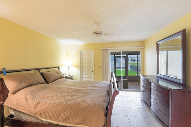 tiled bedroom featuring a closet, a textured ceiling, access to exterior, and ceiling fan