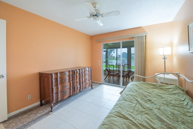 bedroom with a textured ceiling, access to exterior, light tile patterned floors, and ceiling fan