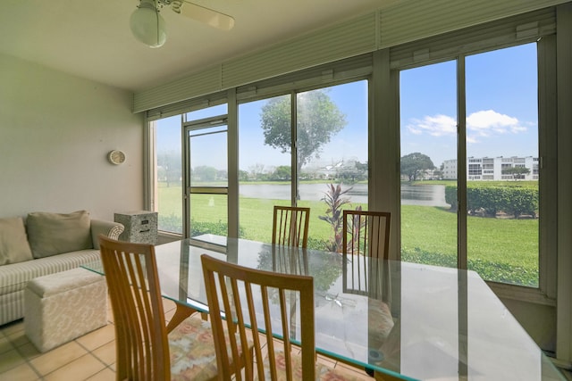 sunroom / solarium featuring a water view and ceiling fan