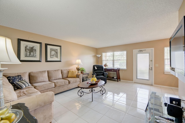 living room featuring a textured ceiling and light tile patterned floors