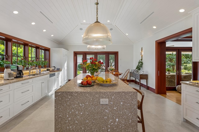 kitchen with a center island, a healthy amount of sunlight, and lofted ceiling