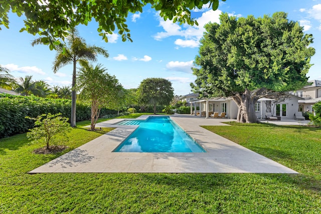 view of pool featuring a lawn and a patio