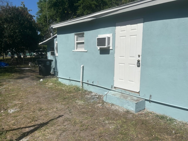 view of side of property with a wall mounted air conditioner