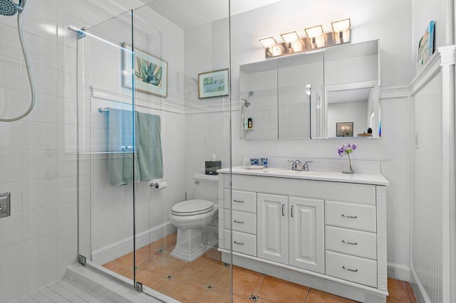 bathroom with tile patterned floors, a shower with door, vanity, and toilet