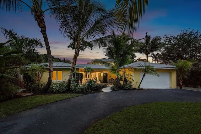 view of front of property with a yard and a garage