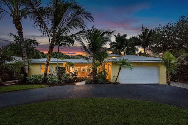 ranch-style home with a garage and a yard