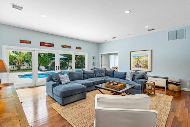 living room with french doors, plenty of natural light, and hardwood / wood-style floors