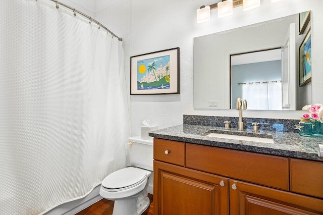 bathroom featuring hardwood / wood-style flooring, walk in shower, vanity, and toilet