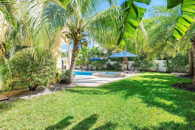 view of yard featuring a swimming pool with hot tub