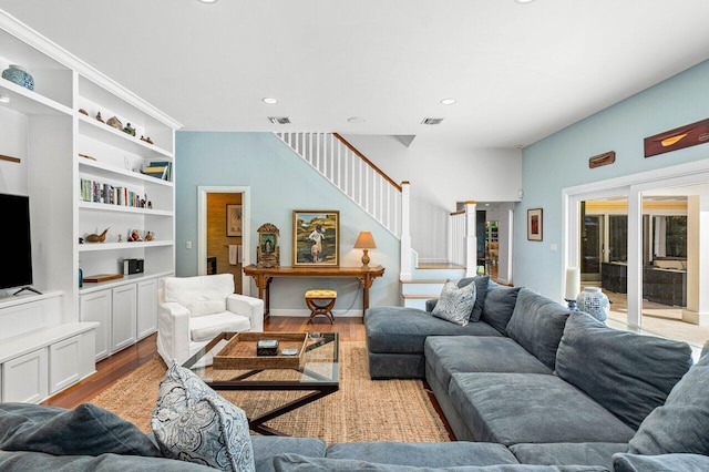 living room with built in shelves and light hardwood / wood-style floors