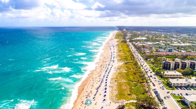 birds eye view of property featuring a water view and a beach view