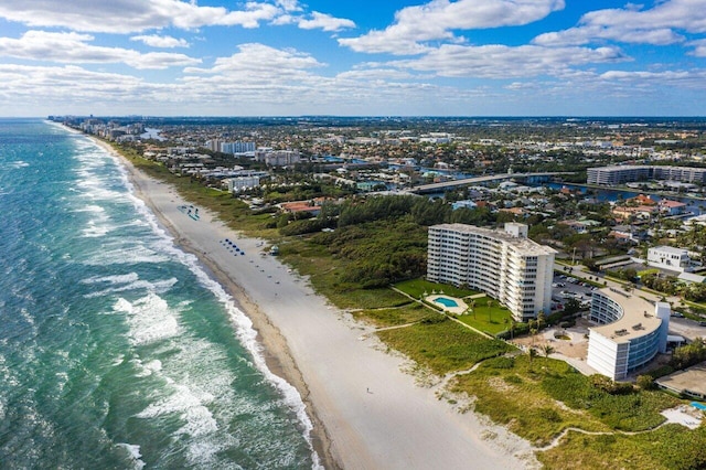 birds eye view of property with a water view and a beach view