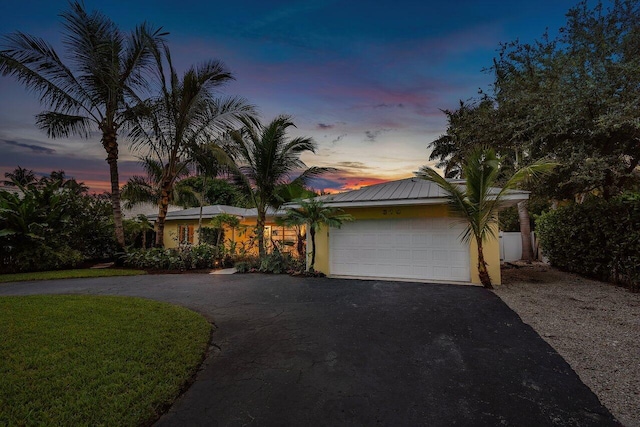 view of front of house with a garage and a yard