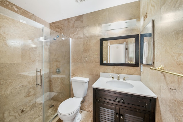 bathroom featuring tile walls, vanity, toilet, and a shower with door