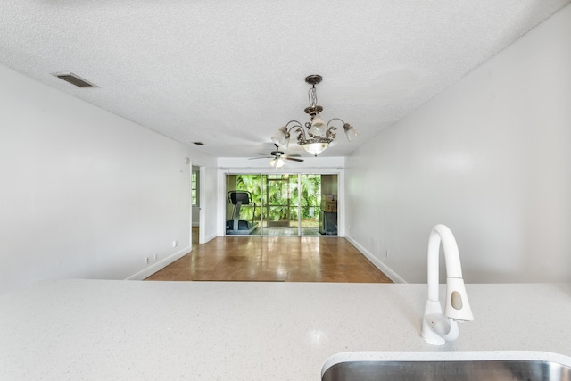 kitchen with sink, pendant lighting, a textured ceiling, and ceiling fan