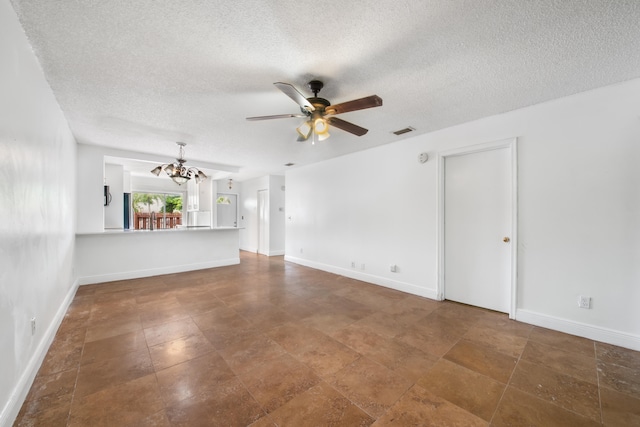 unfurnished living room with ceiling fan with notable chandelier and a textured ceiling