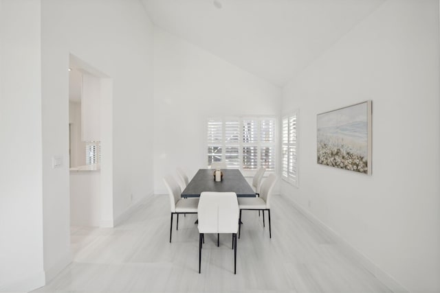 dining room featuring high vaulted ceiling