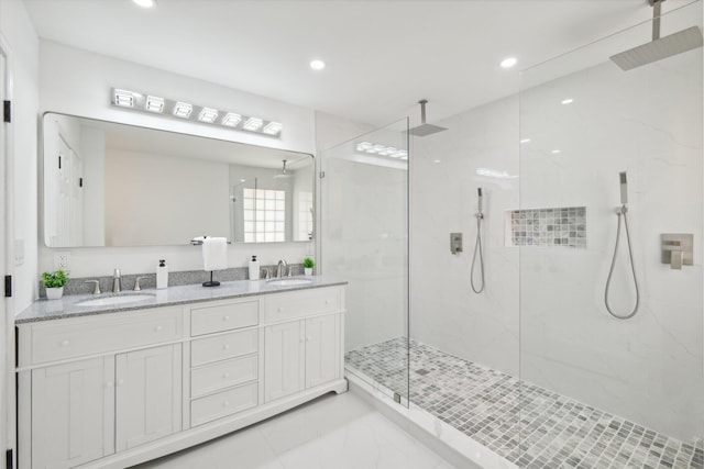 bathroom with a tile shower and vanity