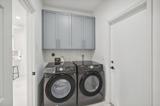 laundry area with washer and clothes dryer and cabinets