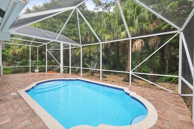 view of swimming pool with a lanai and a patio area