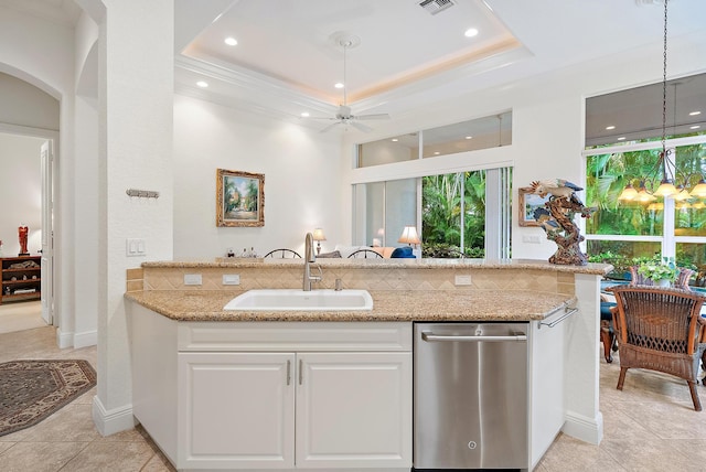 kitchen with light stone countertops, white cabinets, a raised ceiling, and sink