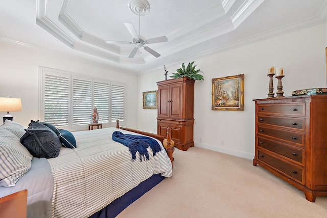 bedroom with ceiling fan, light colored carpet, a raised ceiling, and ornamental molding