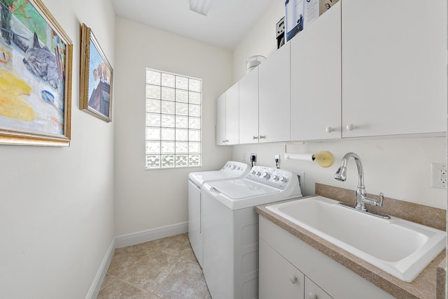 laundry room with cabinets, light tile patterned floors, washer and clothes dryer, and sink