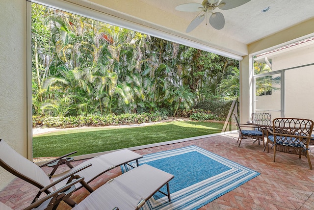 view of swimming pool with ceiling fan, a yard, and a patio