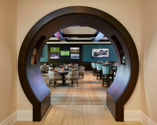 dining area featuring coffered ceiling, beamed ceiling, and tile patterned floors