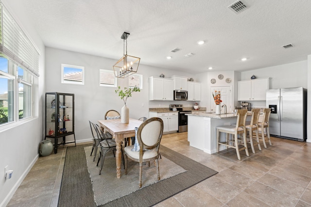 dining area featuring a textured ceiling and a notable chandelier