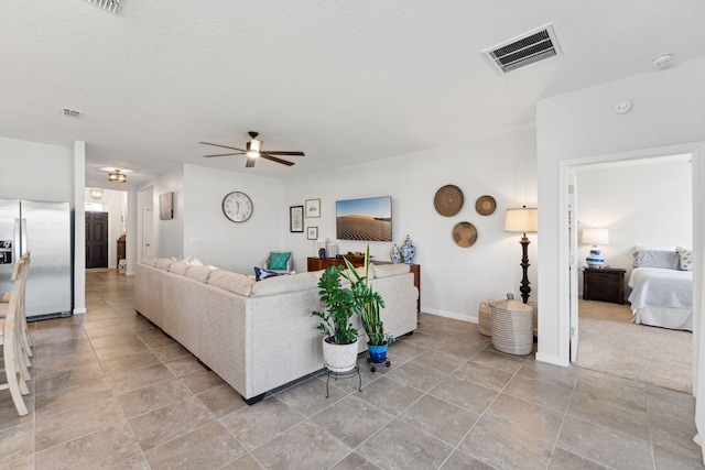 living room with a textured ceiling and ceiling fan