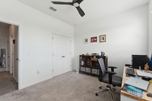 carpeted office space featuring ceiling fan