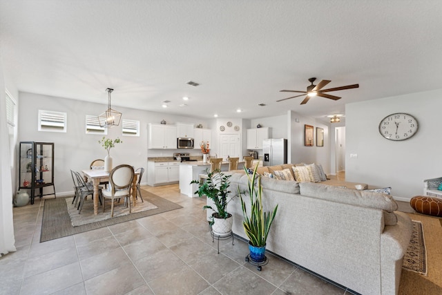 living room with light tile patterned floors, a textured ceiling, and ceiling fan