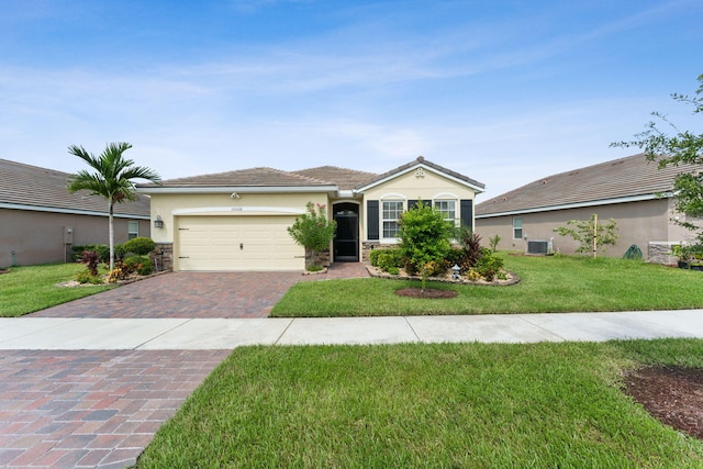 ranch-style house with central AC unit, a garage, and a front lawn