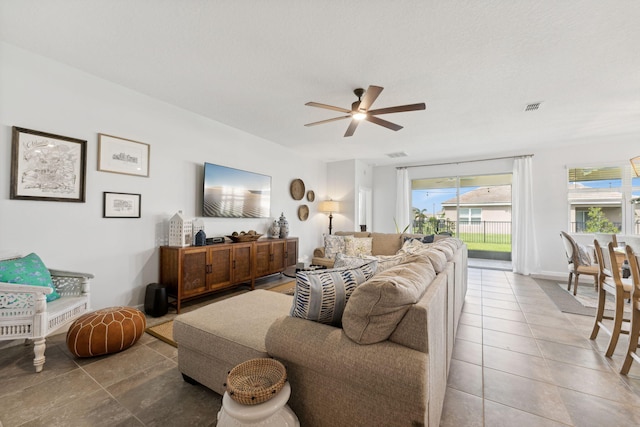 living room featuring ceiling fan and a textured ceiling