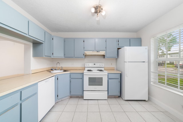 kitchen with a textured ceiling, white appliances, sink, and blue cabinets