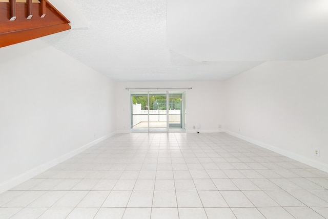 tiled empty room with a textured ceiling