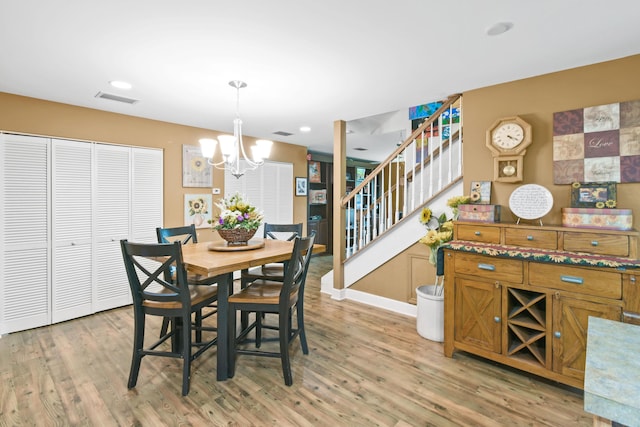 dining space featuring light hardwood / wood-style flooring and a chandelier