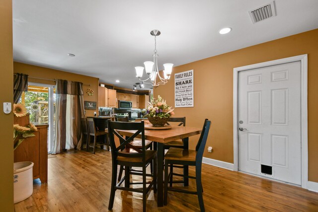 dining room featuring light hardwood / wood-style floors and an inviting chandelier