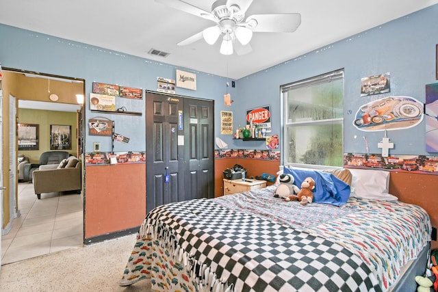 tiled bedroom featuring ceiling fan and a closet