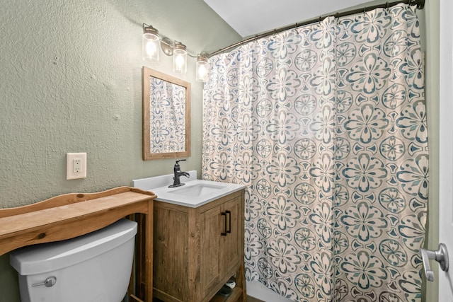 bathroom featuring toilet, vanity, and walk in shower