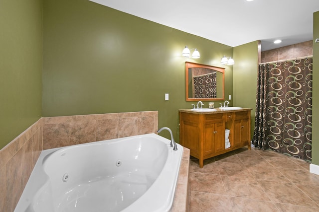 bathroom with tile patterned flooring, tiled tub, and vanity