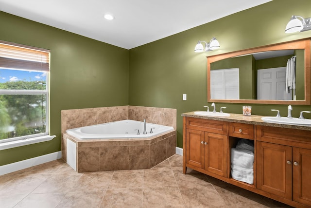 bathroom featuring tiled tub, vanity, and tile patterned floors