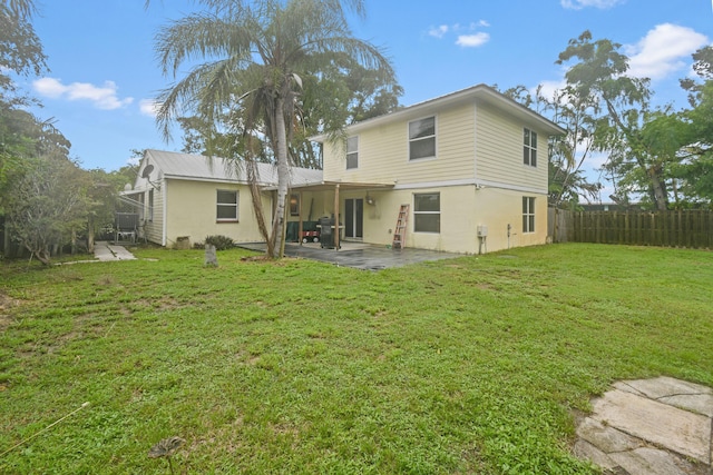 rear view of property featuring a patio and a lawn