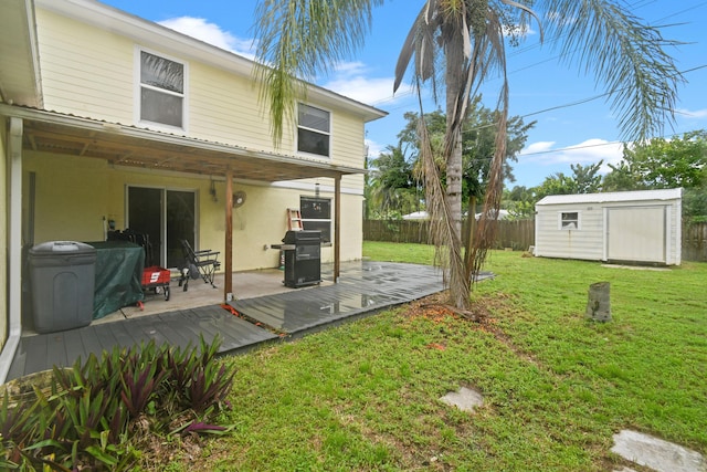 back of property featuring a storage shed, a yard, and a deck