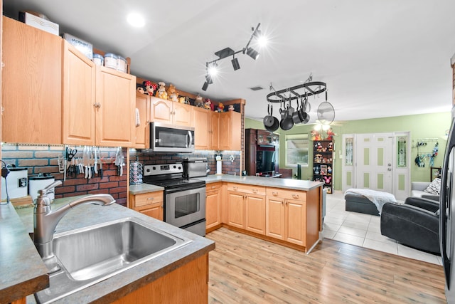 kitchen featuring light brown cabinetry, sink, kitchen peninsula, and stainless steel appliances