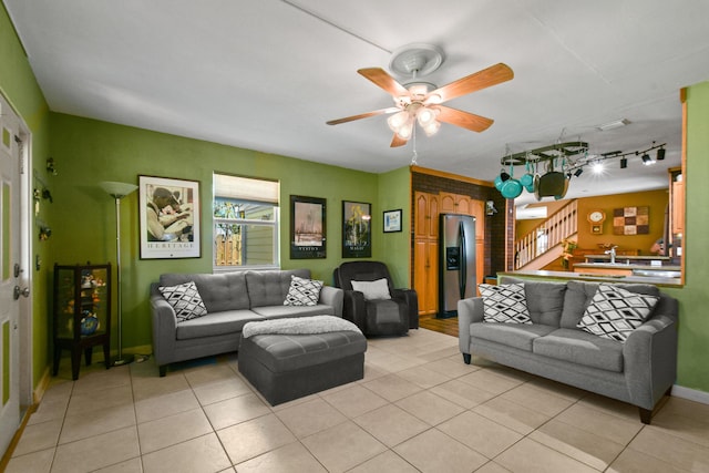 tiled living room with ceiling fan, rail lighting, and sink