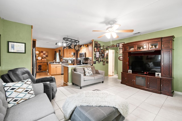 living room with ceiling fan, light tile patterned floors, and sink