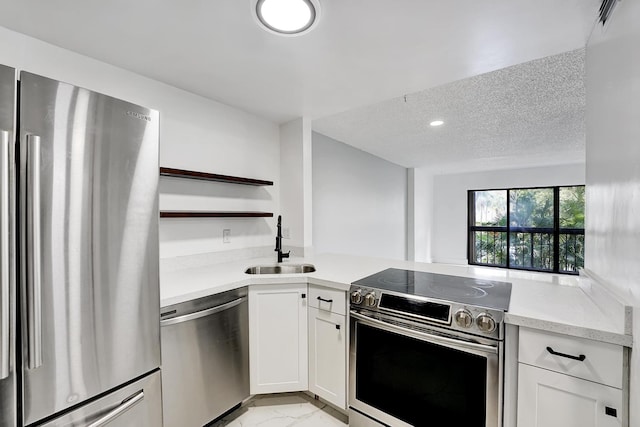 kitchen with white cabinets, a textured ceiling, appliances with stainless steel finishes, and sink