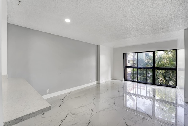 unfurnished room with a textured ceiling